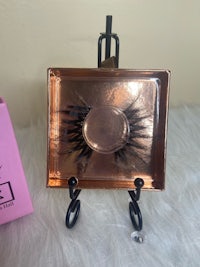 a pair of false lashes on a table with a box