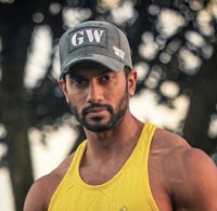 a man in a yellow tank top posing for a picture