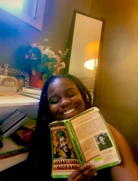 a woman smiling while holding a book