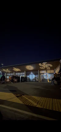 an airport at night with cars parked in front of it
