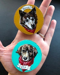 two wooden magnets with two dogs on them