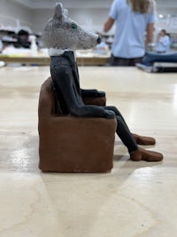 a statue of a person sitting on a chair
