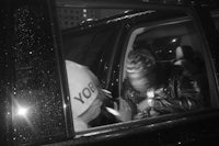 a black and white photo of two people in a car