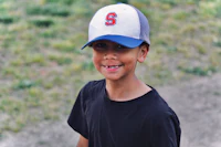 a young boy wearing a baseball cap