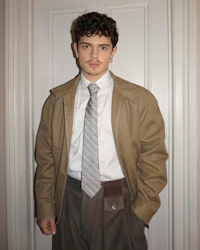 a man wearing a tan jacket and pants