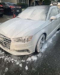 a white audi a4 being washed in a driveway