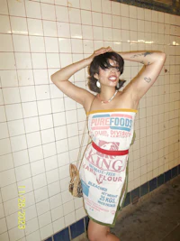 a woman in a dress posing against a wall