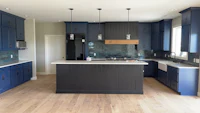 a kitchen with blue cabinets and a wooden floor