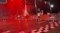 a video of people running on a track in front of a red light