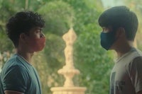 two young men wearing face masks standing next to each other