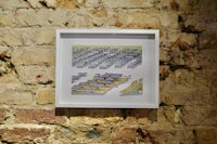 a framed drawing hanging on a brick wall