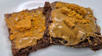two pieces of brownies with peanut butter frosting on a plate