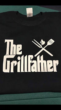 the grillfather logo on a black t - shirt