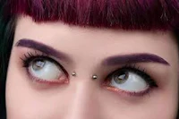 a woman with purple hair and piercings