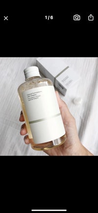 a person holding up a bottle of soap