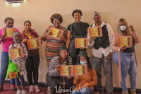 a group of people holding certificates in front of a wall