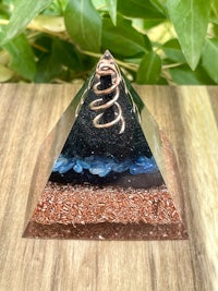 a glass pyramid with blue and brown stones on it