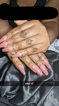 a woman with pink nails holding a pink nail polish