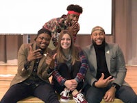 four people posing for a picture on stage