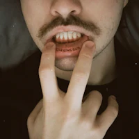 a man with a mustache licking his lips