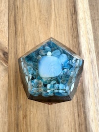 a blue hexagonal box with blue stones in it