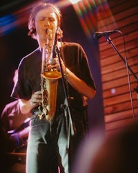 a man playing a saxophone on stage