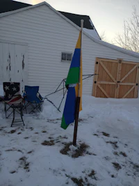 a blue and yellow kite in the snow