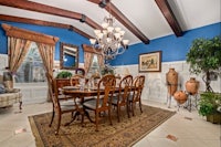 a dining room with blue walls and a chandelier