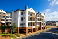 a large apartment building with balconies and umbrellas