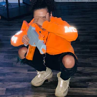 a woman holding a nerf gun while crouching on the floor