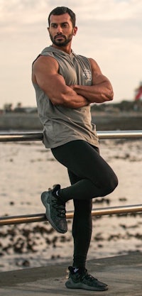 a man leaning against a railing near the water