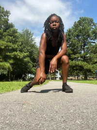 a young woman squatting on a path