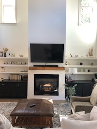 a living room with a tv above the fireplace