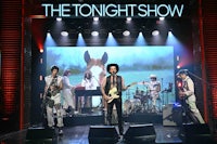 the tonight show logo with a group of people on stage