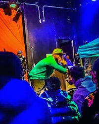 a man on stage with a microphone in front of a crowd