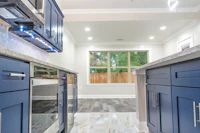 a kitchen with blue cabinets and granite counter tops