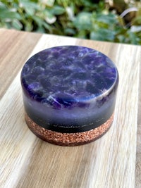 an amethyst and copper box on top of a wooden table