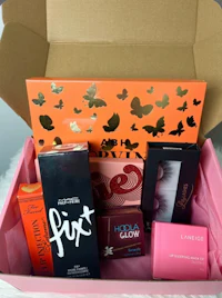 a pink box filled with cosmetics and other items
