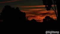 a silhouette of a sunset with trees in the background