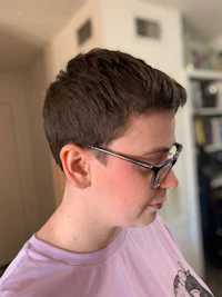a woman wearing glasses and a purple shirt in a living room