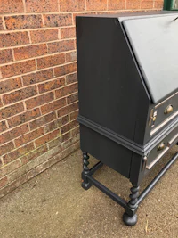 a black desk with a brass handle on it
