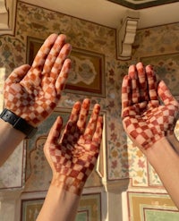 hands with henna painted on them in rajasthan, india