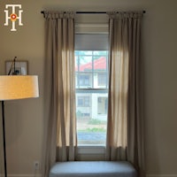 a window with curtains and a bench in front of it