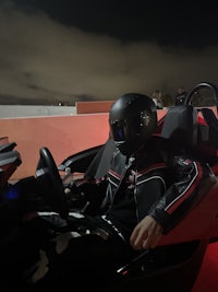 a person in a helmet sitting in a car at night