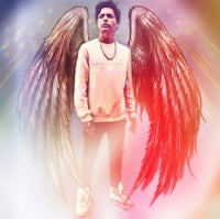 a man with angel wings standing in front of a colorful background