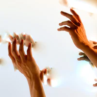 a group of people reaching for something on a white wall