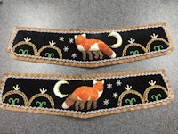 a pair of embroidered foxes on a table