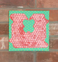 a piece of art with polka dots on a brick wall