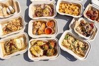 a variety of food in paper trays on a table