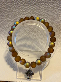 a bracelet with brown opal beads on a clear stand